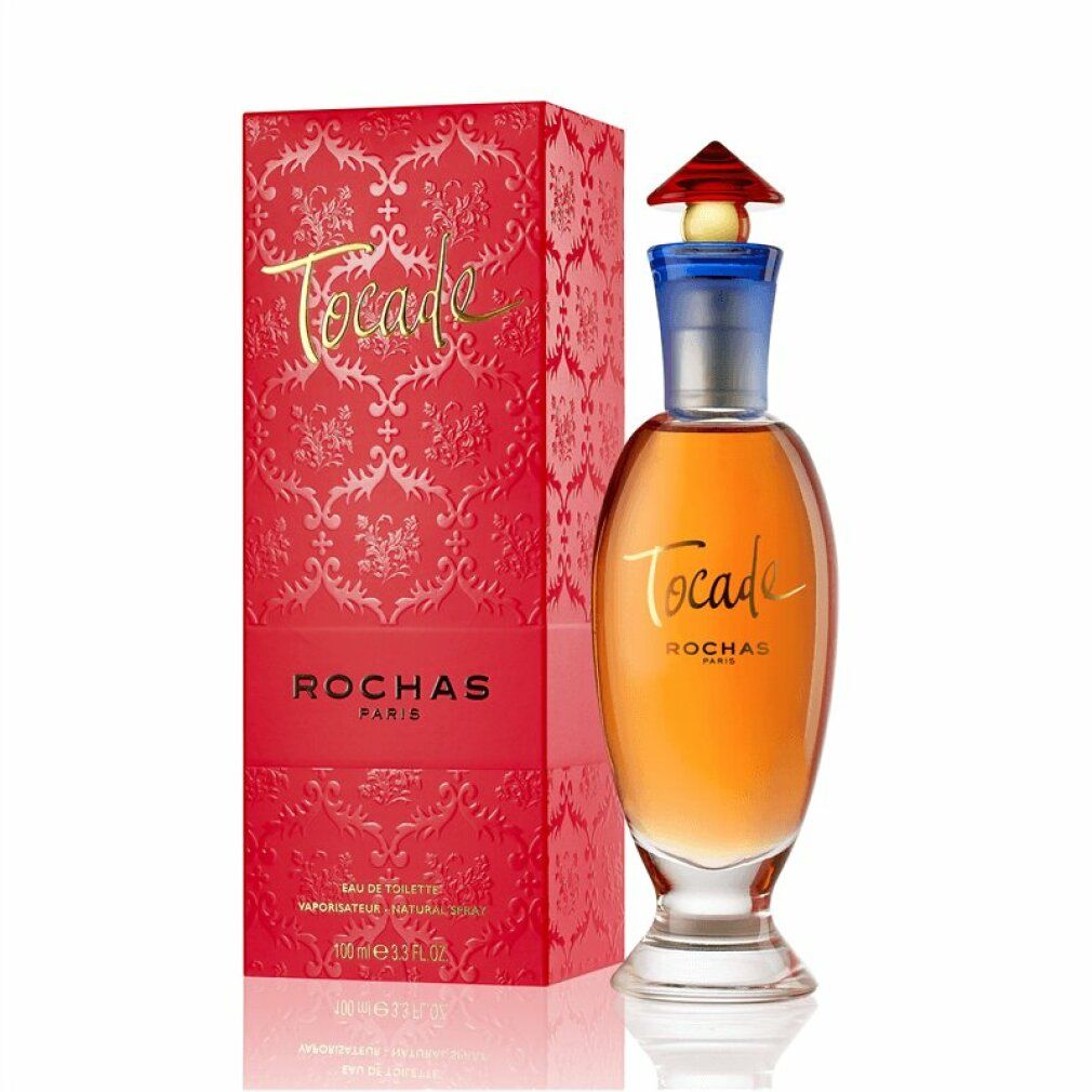 Flacon de parfum et emballage rouge. Inscription "TOCADE" et "ROCHAS PARIS". Flacon avec col bleu et bouchon rouge.