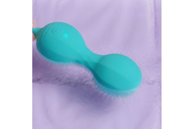 Produit de bien-être turquoise avec deux sphères reliées. Posé sur une surface douce et floue.