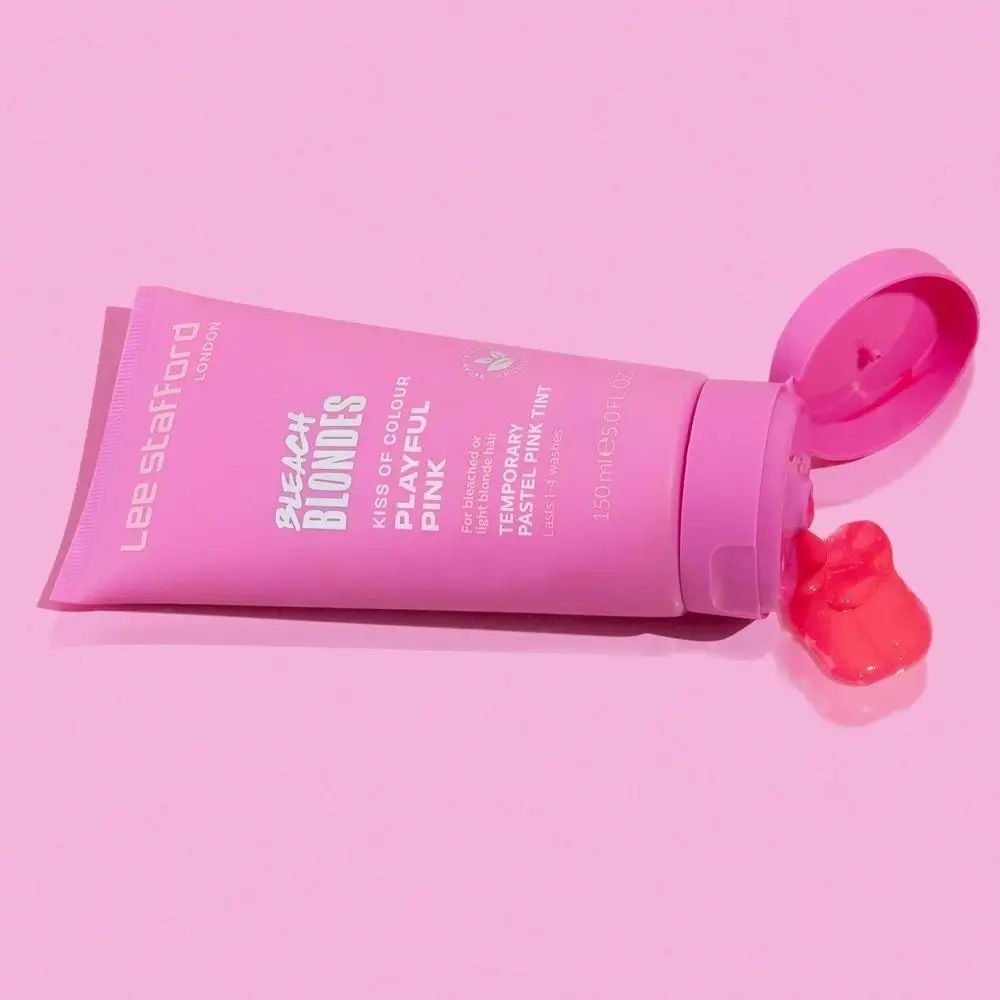 Roze tube ligt op roze achtergrond. Product komt uit opening. Productnaam en tekst op de tube.