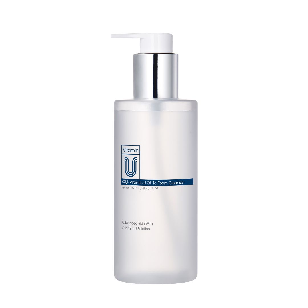 Transparante fles met pomp. Opschrift: Vitamin U Oil to Foam Cleanser. Zilveren pomp, witte dispenser.