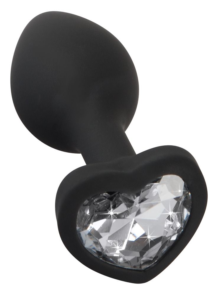 Hand die een zwarte siliconen butt plug met hartvormige strass steen vasthoudt.