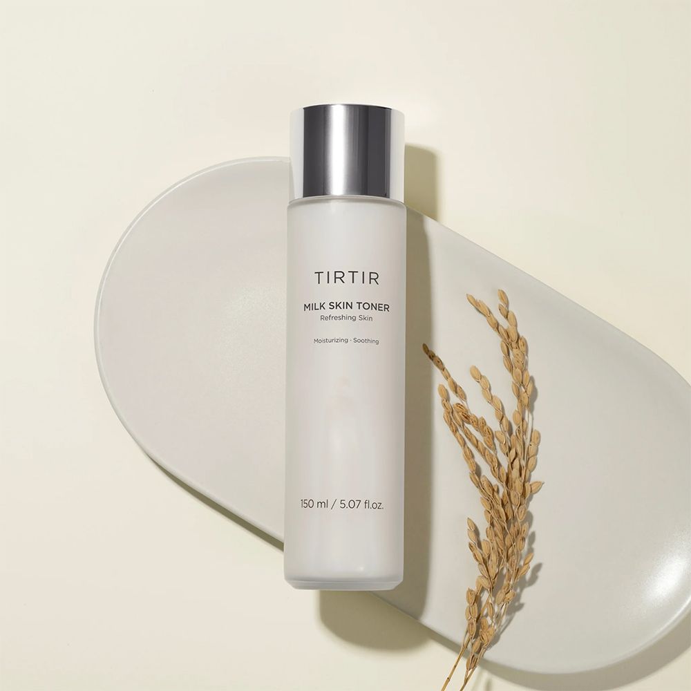 Bouteille de TIRTIR Milk Skin Toner sur une assiette avec épi de riz. 150 ml / 5.07 fl.oz.