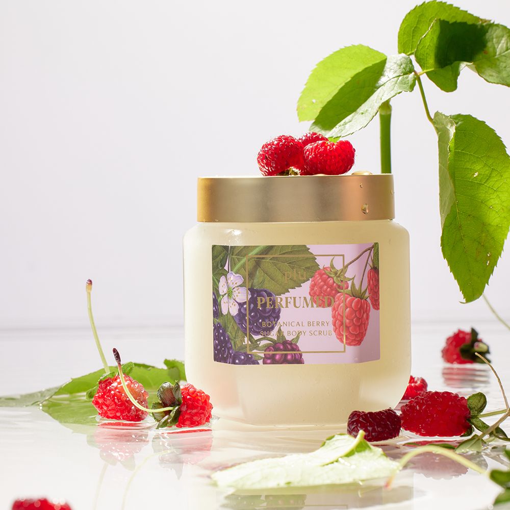 Glazen pot met gouden deksel, omringd door bladeren en bessen. Etiket met bessen- en bloemenillustraties. Opschrift: PERFUMED BOTANICAL BERRY.