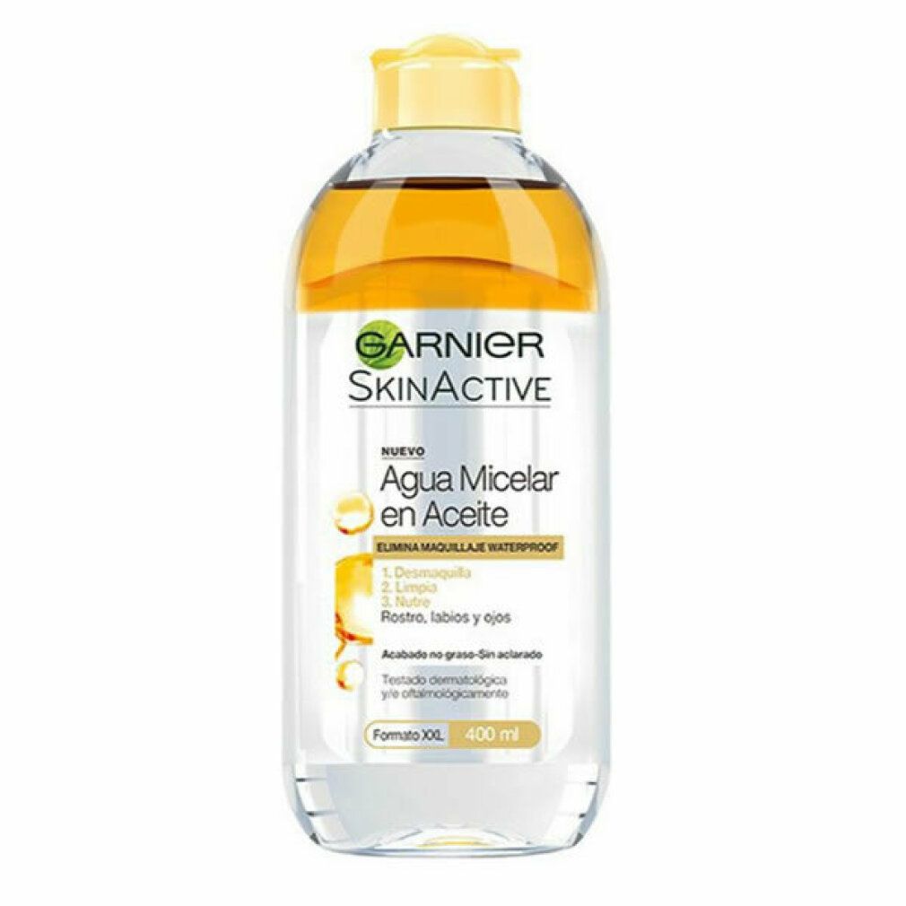 Transparante fles met gele vloeistof en gele dop. Opschrift Garnier SkinActive, Agua Micelar en Aceite. 400 ml.