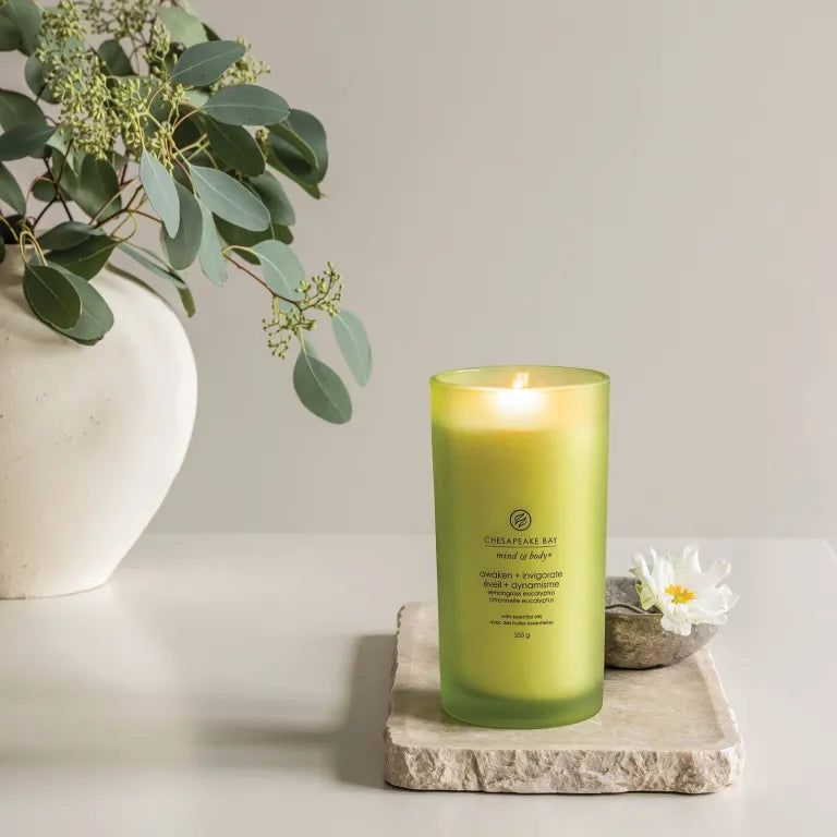 Bougie verte allumée en verre. Inscription: Chesapeake Bay mind & body, awaken + invigorate, 355 g.