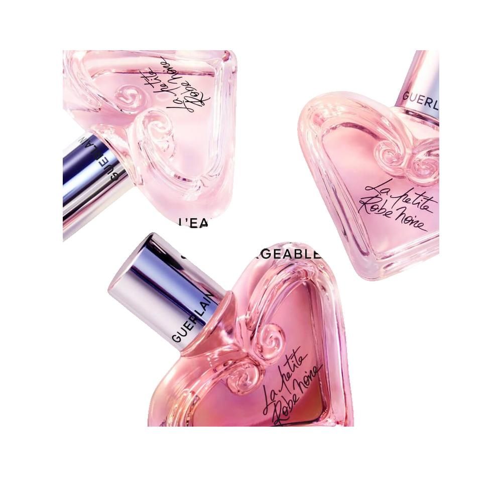 Drie roze hartvormige flacons met zilveren doppen. Opschrift: La petite Robe noire. Merk: Guerlain.