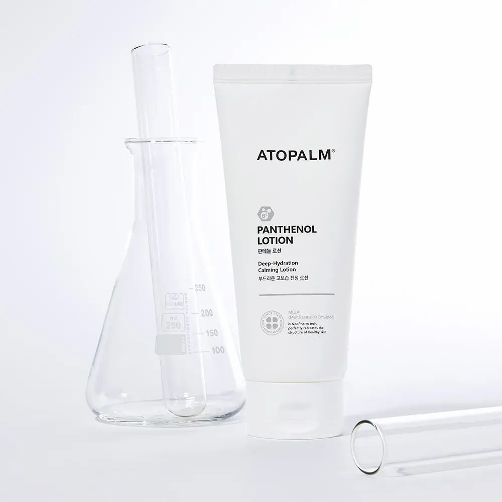 Tube blanc ATOPALM, texte PANTENOL LOTION. Verrerie de laboratoire : bécher, tube à essai. Fond blanc.