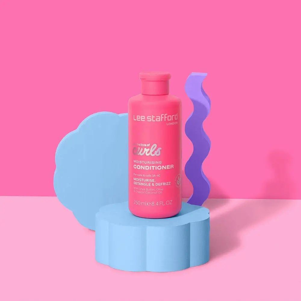 Roze fles op blauwe sokkel. Tekst: For the love of curls, Moisturising Conditioner. Achtergrond: roze en blauwe vormen.