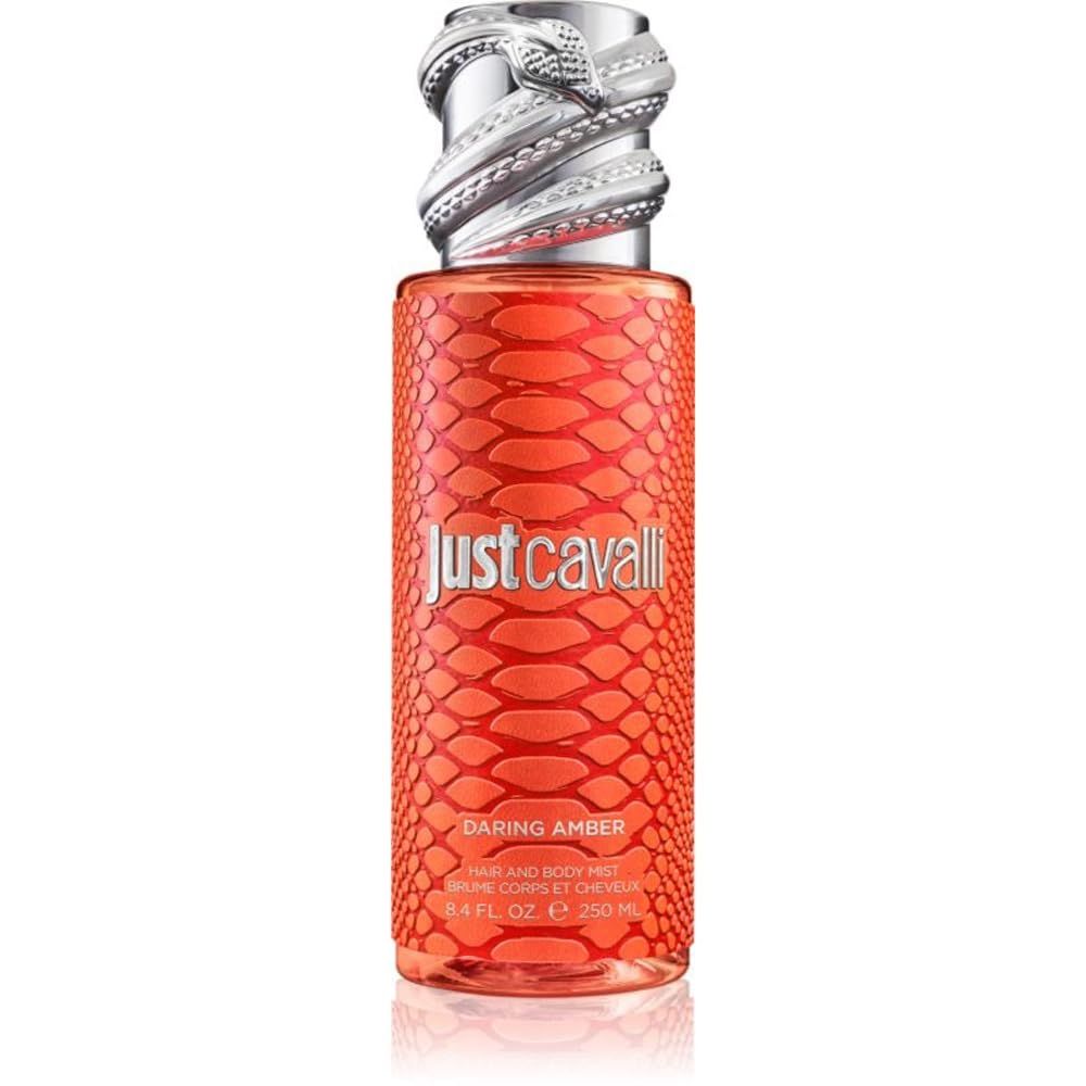 Flacon orange à motif peau de serpent avec un bouchon argenté en forme de tête de serpent. "Just Cavalli Daring Amber Hair and Body Mist" est imprimé.