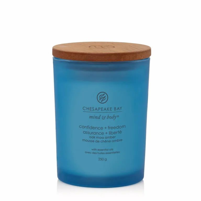 Bougie bleue en verre avec couvercle en bois. Texte: Chesapeake Bay, mind & body, confidence + freedom, oak moss amber, 250 g.