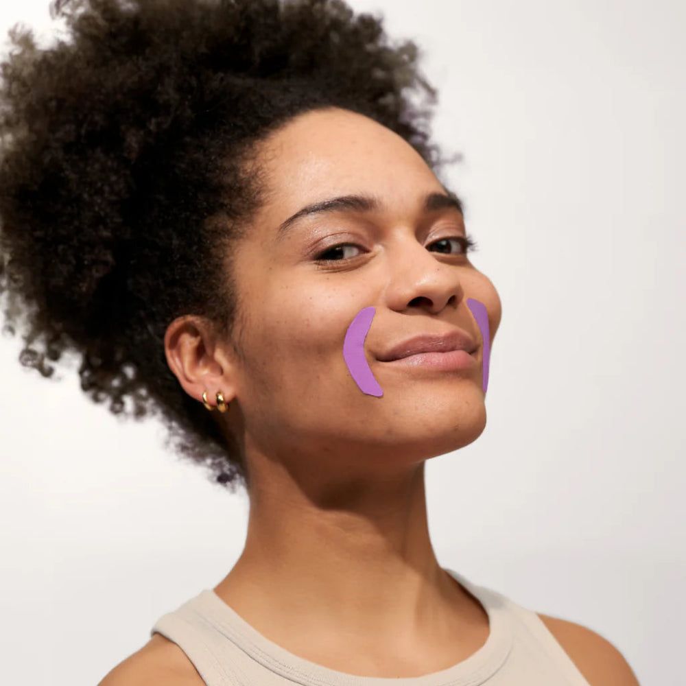Vrouw met paarse mondpatches. Patches op de mondhoeken. Huidskleur, donker haar.