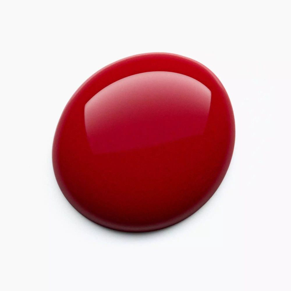 Goutte de vernis à ongles rouge sur fond blanc. Surface brillante.