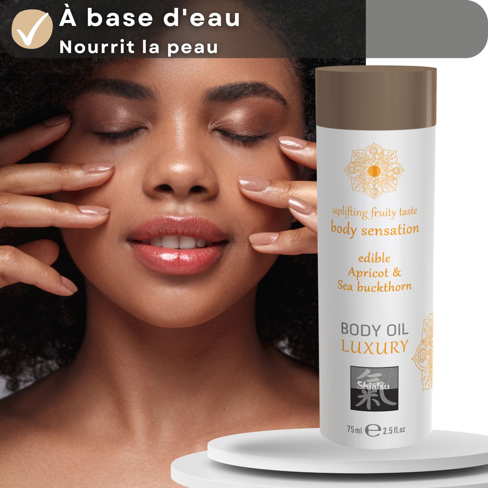 Flacon Shiatsu Body Oil Luxury devant le visage d'une femme.