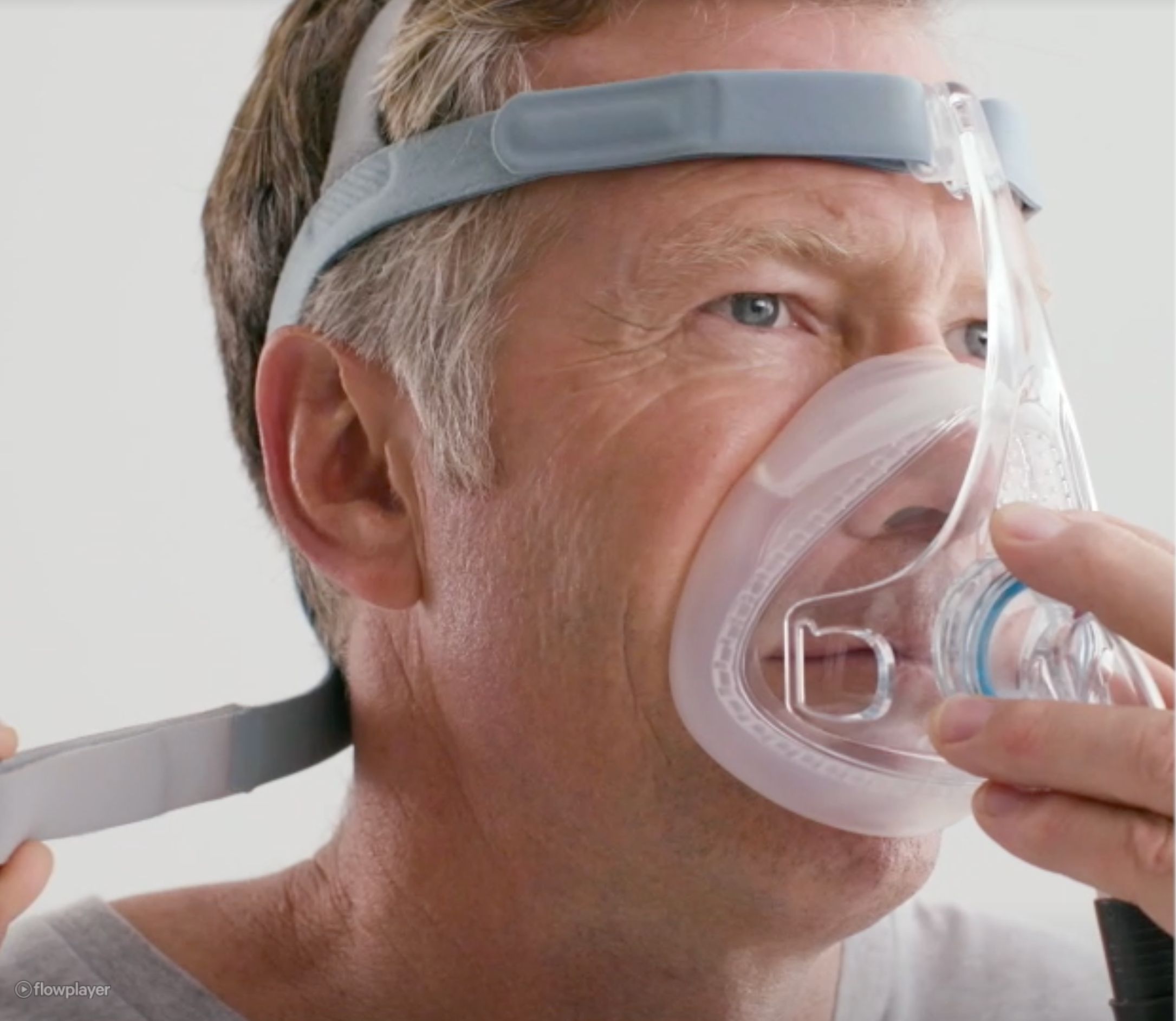Homme mettant un masque CPAP. Gros plan sur le visage et le masque.