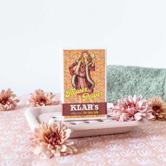 Klar's zeep, verpakt, op een zeepbakje met bloemen. Opdruk: Flower Power, vrouw met zeep. Onder: Klar's, zeep uit de jaren 70.