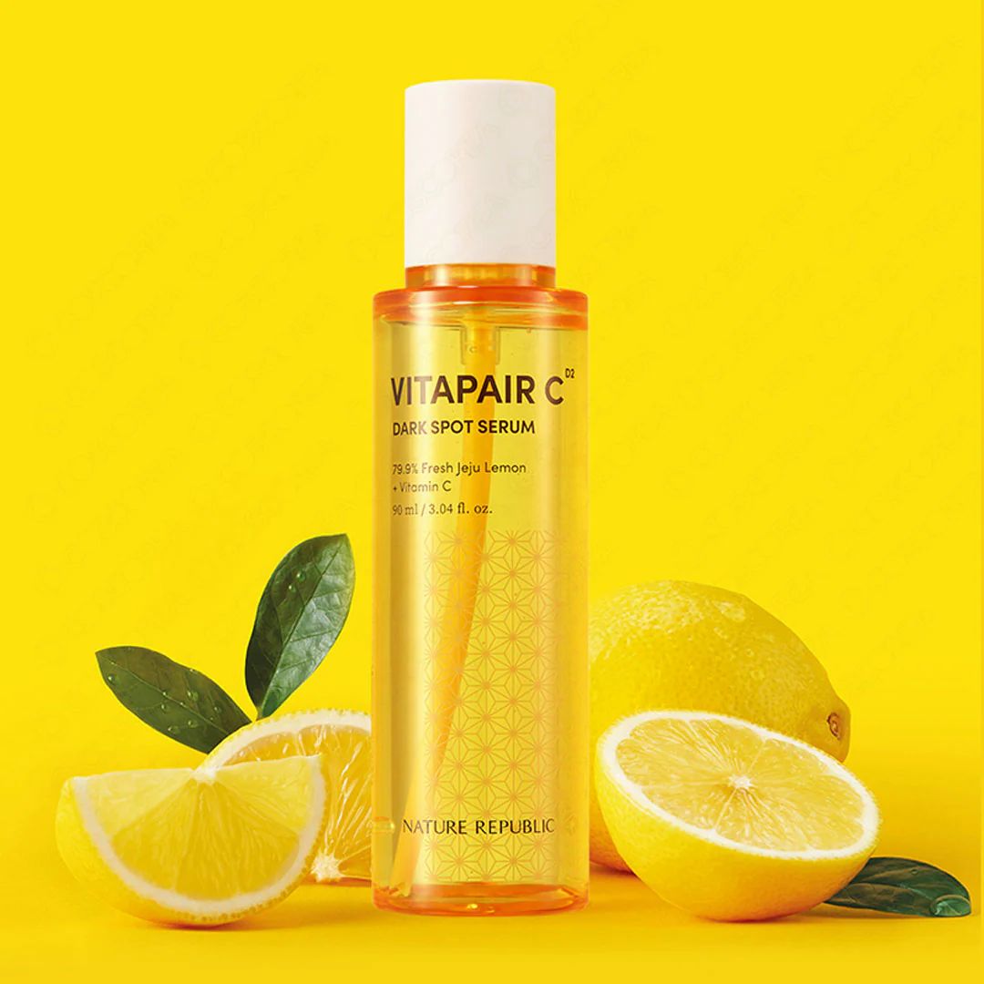 Geel serumflesje met witte dop, omringd door citroenen en bladeren. Opschrift: VITAPAIR C, NATURE REPUBLIC.