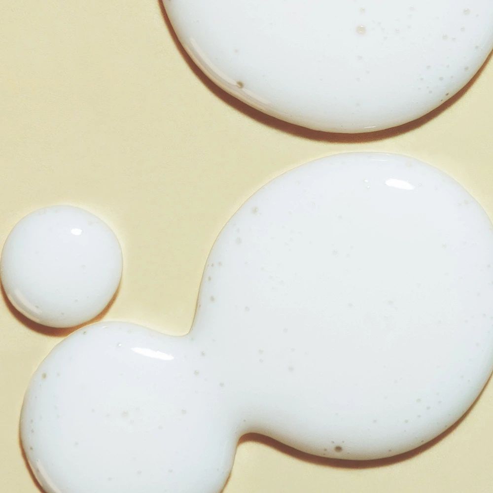 Drie witte druppels op gele achtergrond. De druppels hebben verschillende maten en vormen.