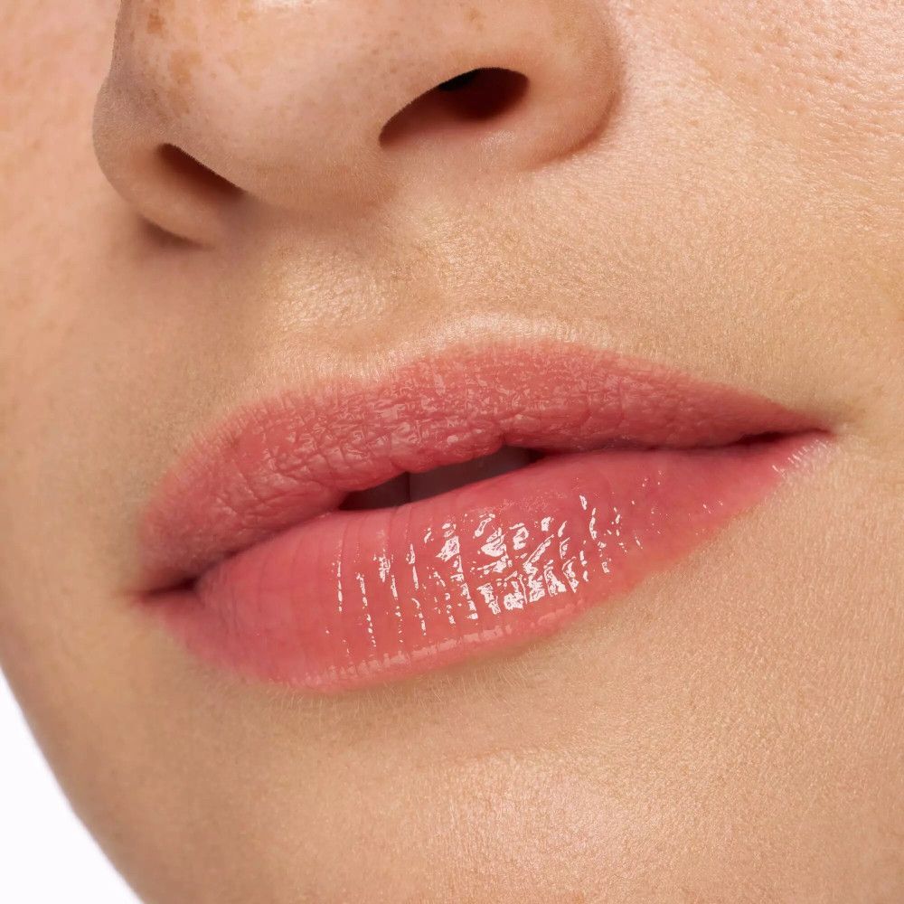 Gros plan sur des lèvres avec du rouge à lèvres rose. Fini brillant.