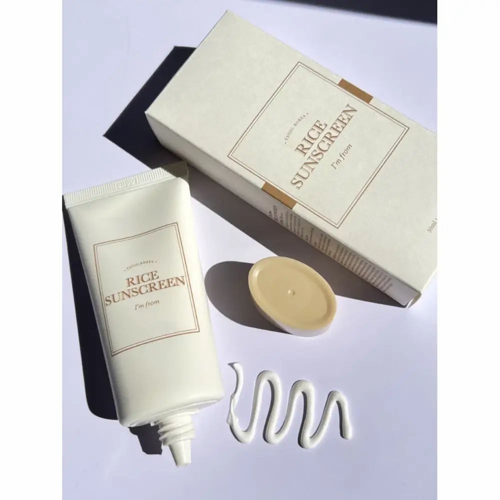Crèmetube, doos en deksel. Opschrift 'Rice Sunscreen' en 'I'm from'. Streepje crème.