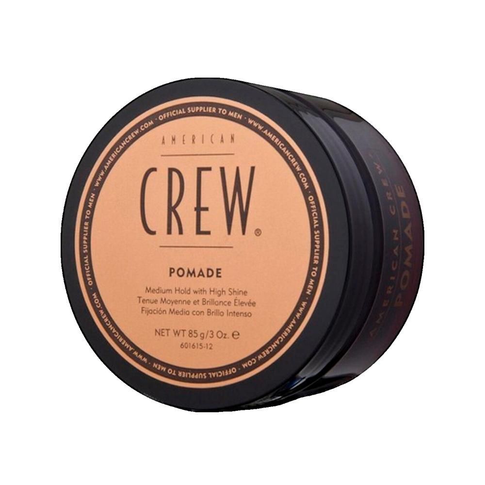 Ronde zwarte pot met bruin deksel. Opschrift: AMERICAN CREW. Pomade. Netto 85 g/3 Oz.