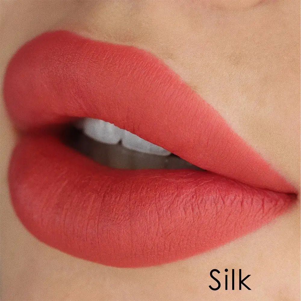 Close-up van lippen met rode lippenstift. De tekst 'Silk' is onderaan zichtbaar.