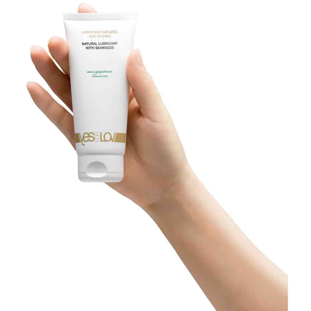 Tube blanche tenue dans une main. Inscription: Natural Lubricant with Seaweeds, sans glycerine. Marque: YESforLOV.