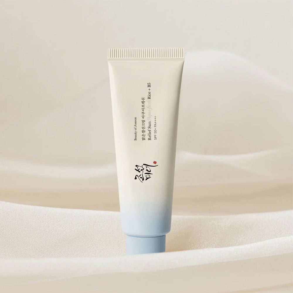 Tube blanc avec bouchon bleu, crème solaire au riz et B5.