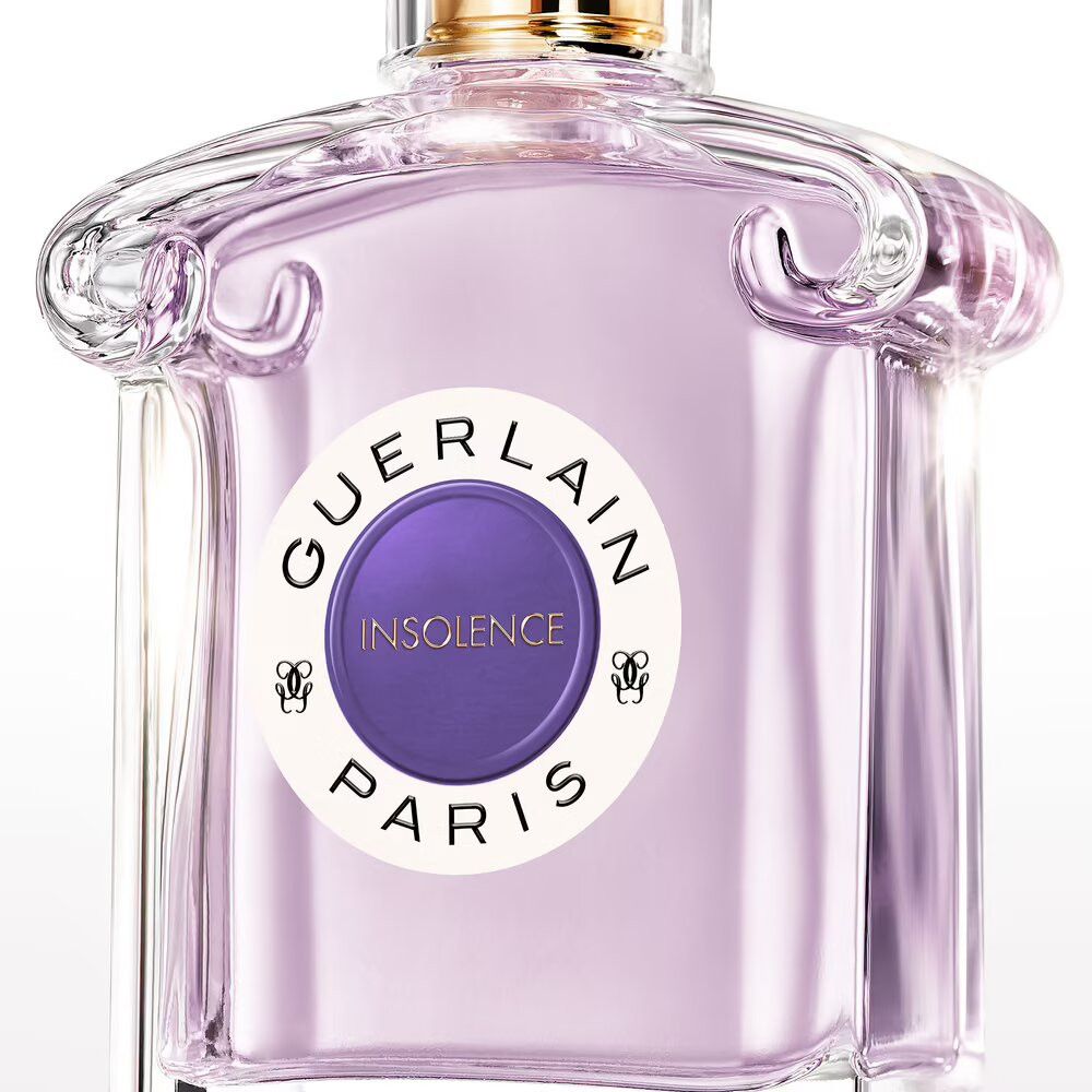 Flacon en verre avec liquide violet. Étiquette "GUERLAIN INSOLENCE PARIS". Bouchon doré. Vaporisateur transparent.