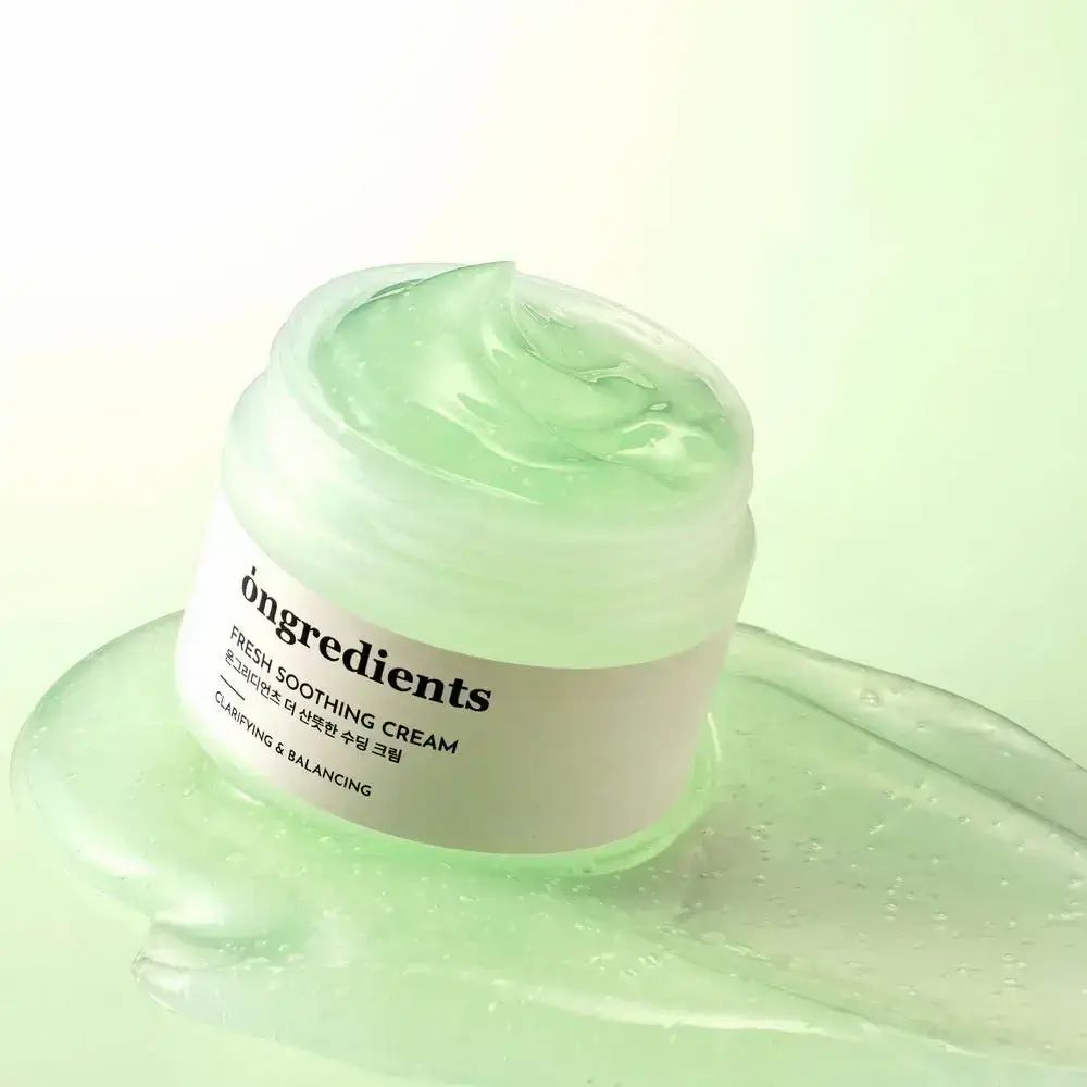 Pot de crème ouvert avec crème verte. Inscription : ONGREDIENTS, FRESH SOOTHING CREAM, texte coréen, CLARIFYING & BALANCING. Crème étalée sur fond.