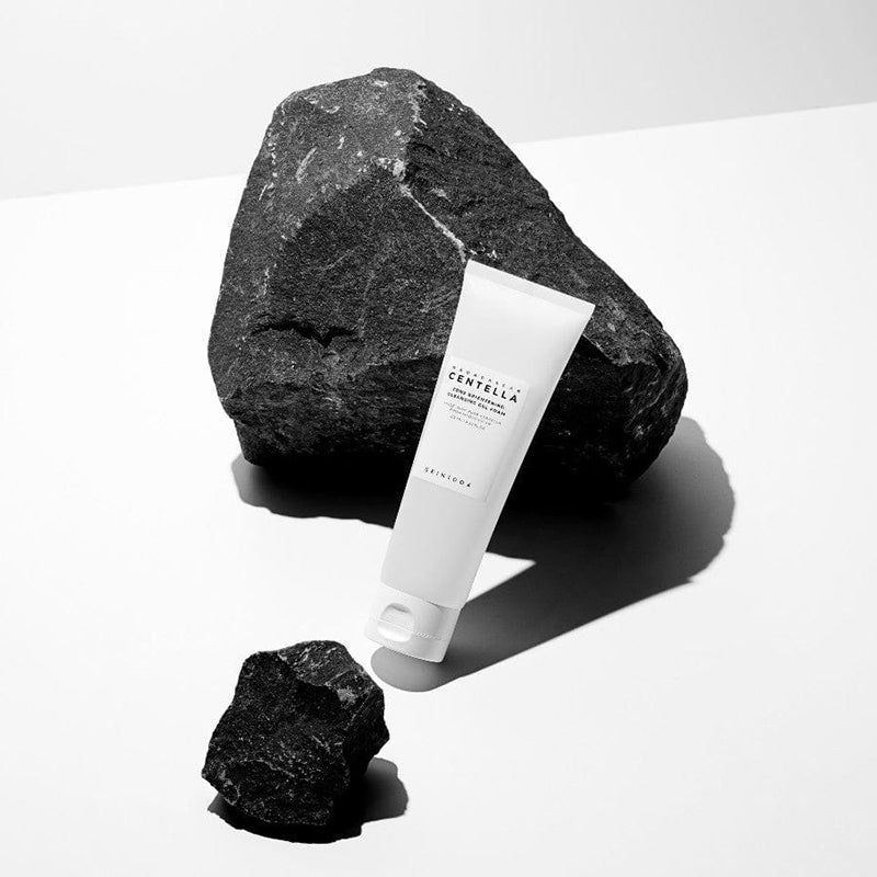 Tube blanc, pierres noires. Texte: MADAGASCAR CENTELLA, Tone Brightening Cleansing Gel Foam. Marque SKIN1004.