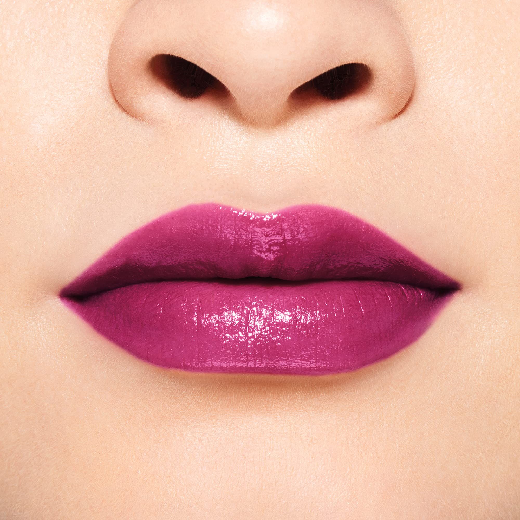 Gros plan sur des lèvres maquillées avec un rouge à lèvres rose-violet. Teint clair.