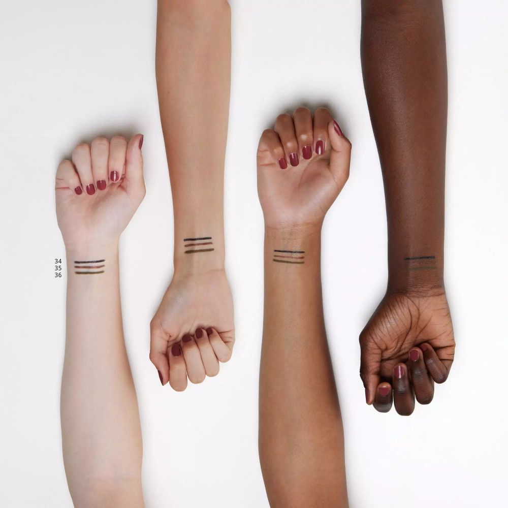 Quatre bras avec traits de crayon pour les yeux sur les poignets. Différents tons de peau. Texte: Essence.