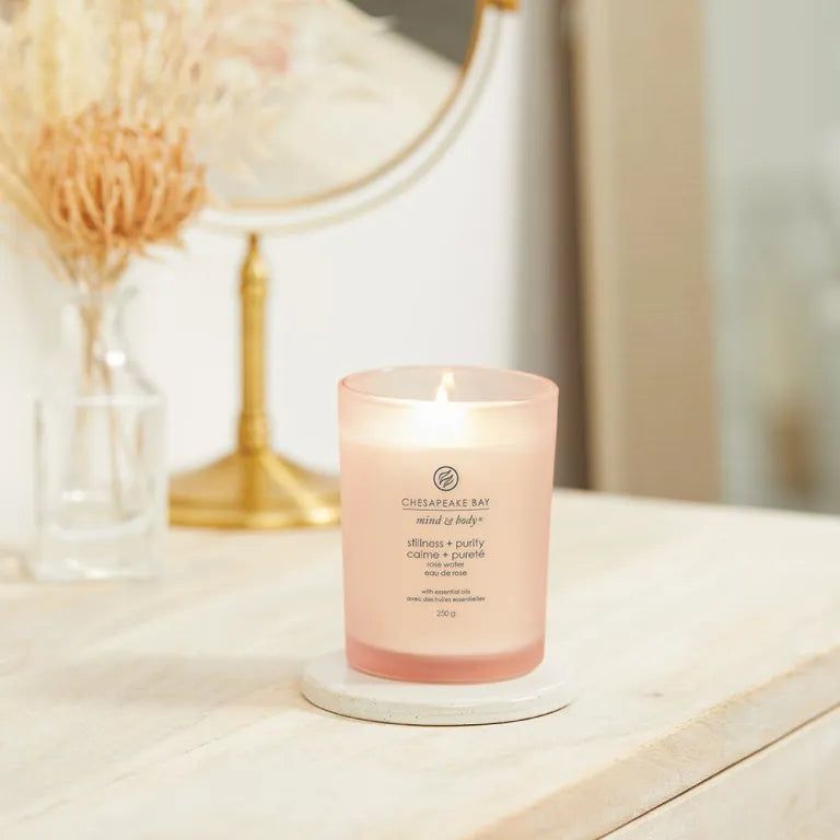 Bougie Chesapeake Bay allumée, mind & body, stillness + purity, 250g. Sur dessous de plat blanc, miroir en arrière-plan.