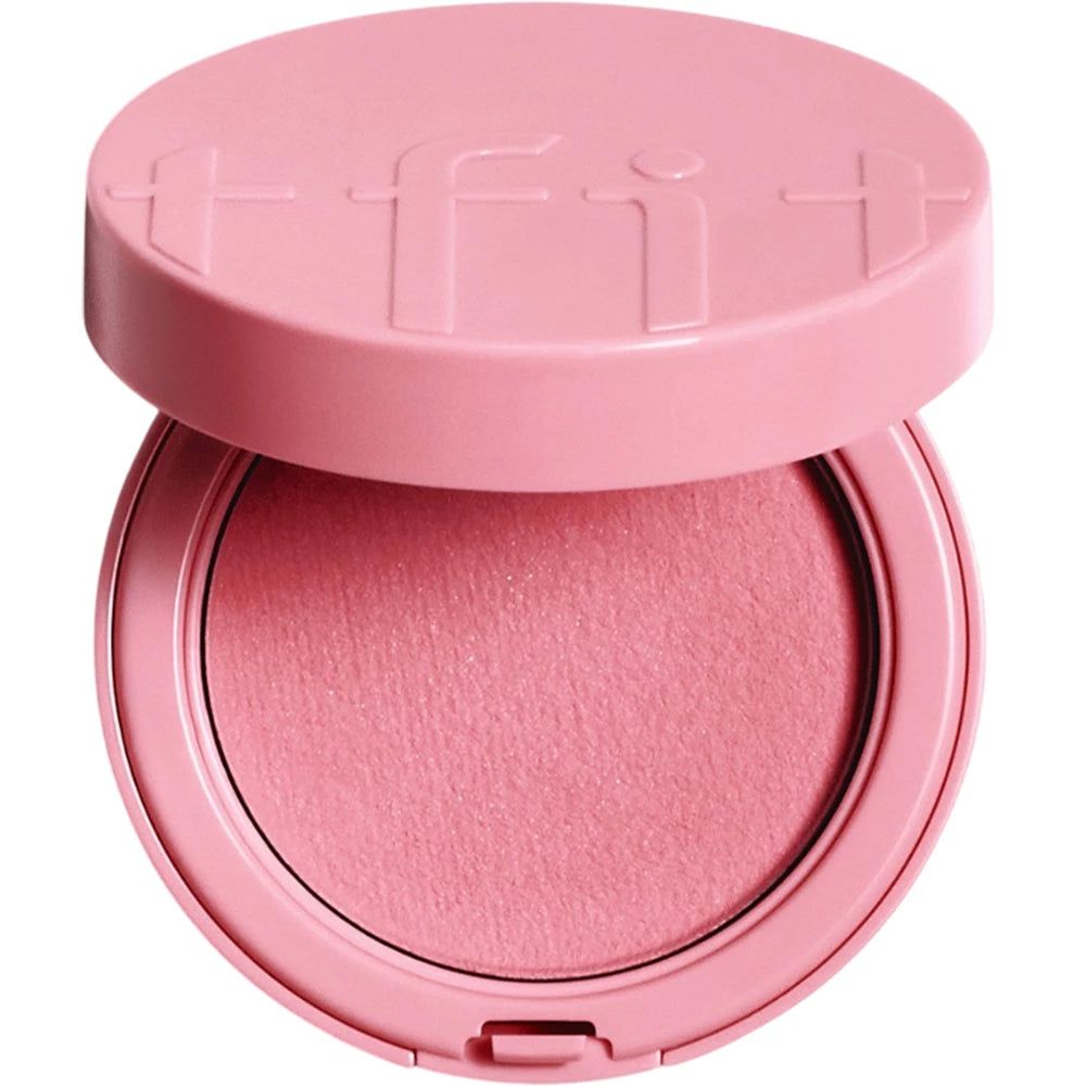 Poudre compacte blush rose, ronde, avec couvercle ouvert. Le couvercle porte le nom de la marque 'tfit'.