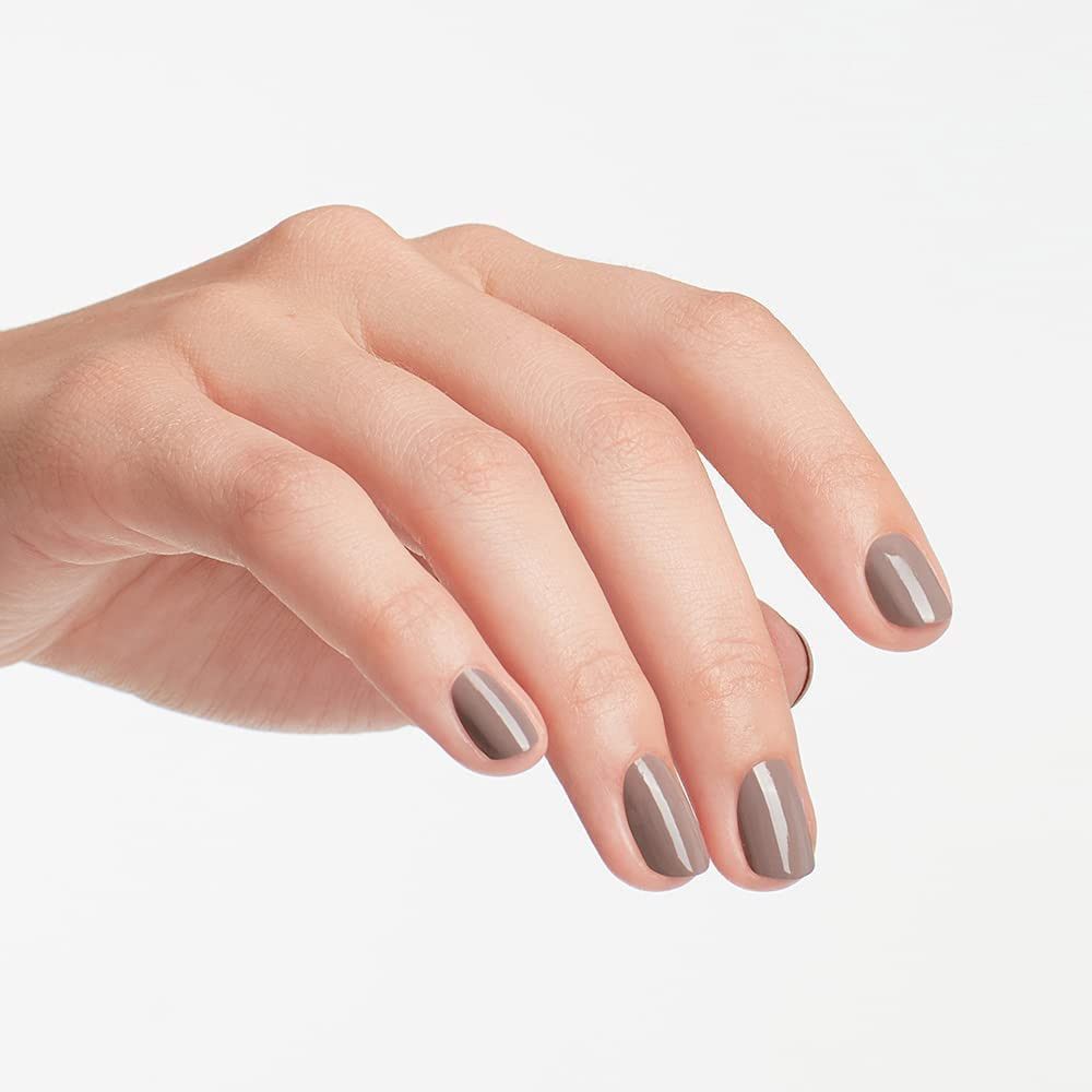 Hand met gelakte nagels in bruin-grijs. Gelakte nagels.