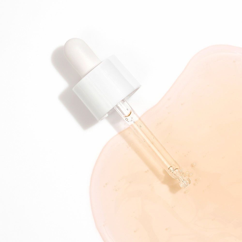 Pipette avec sérum Dr. Melaxin Cemenrete sur une flaque de liquide.