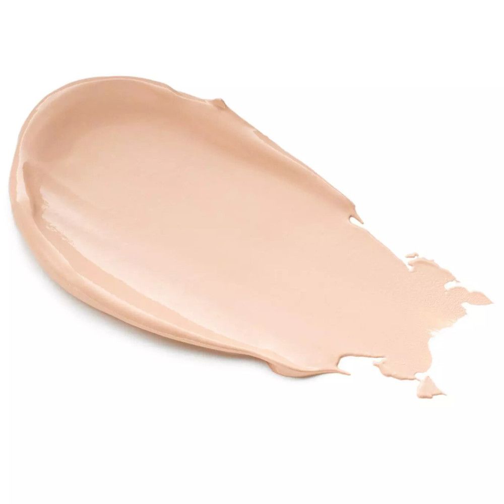 Couche de crème beige sur fond blanc. La texture est lisse et crémeuse.