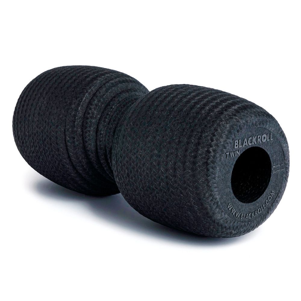 Rouleau de massage TWIN BLACKROLL® noir. Deux rouleaux cylindriques reliés. Logo et nom du produit sur la surface.