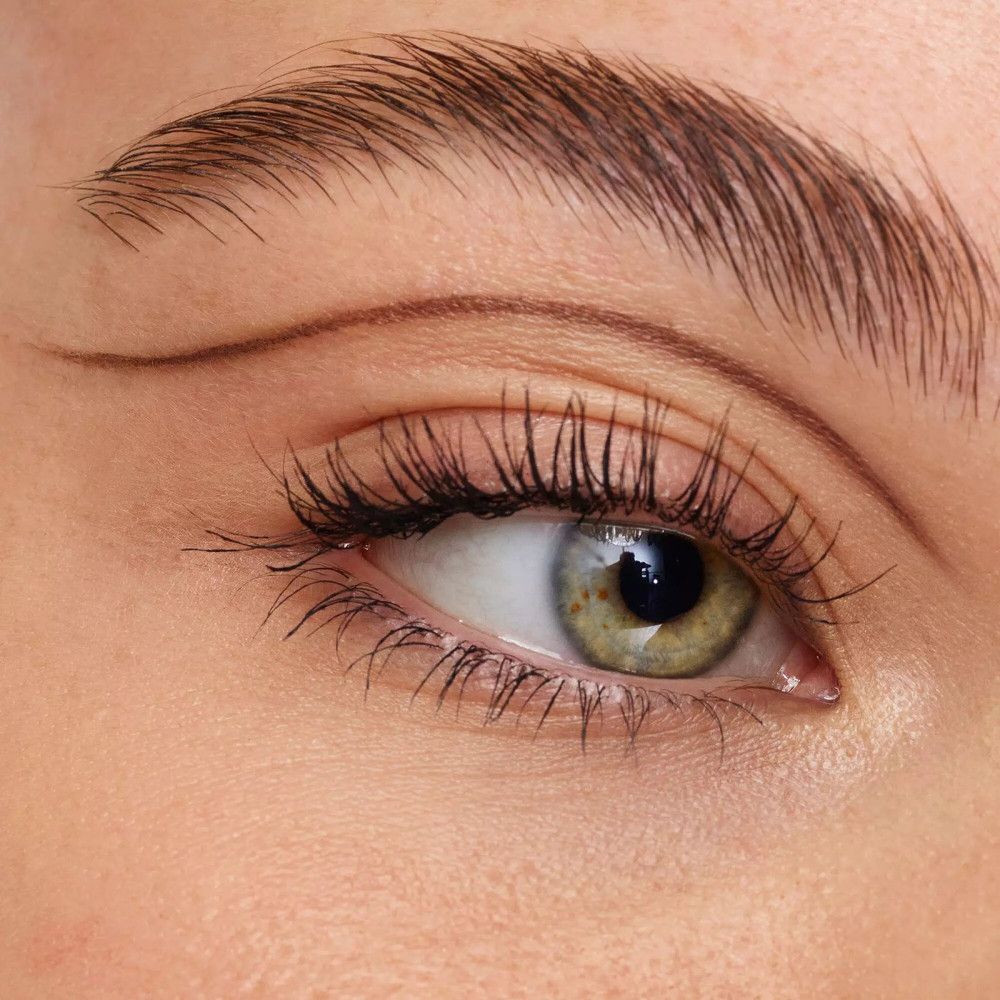 Gros plan sur un œil avec un trait d'eye-liner. Iris verte, longs cils.