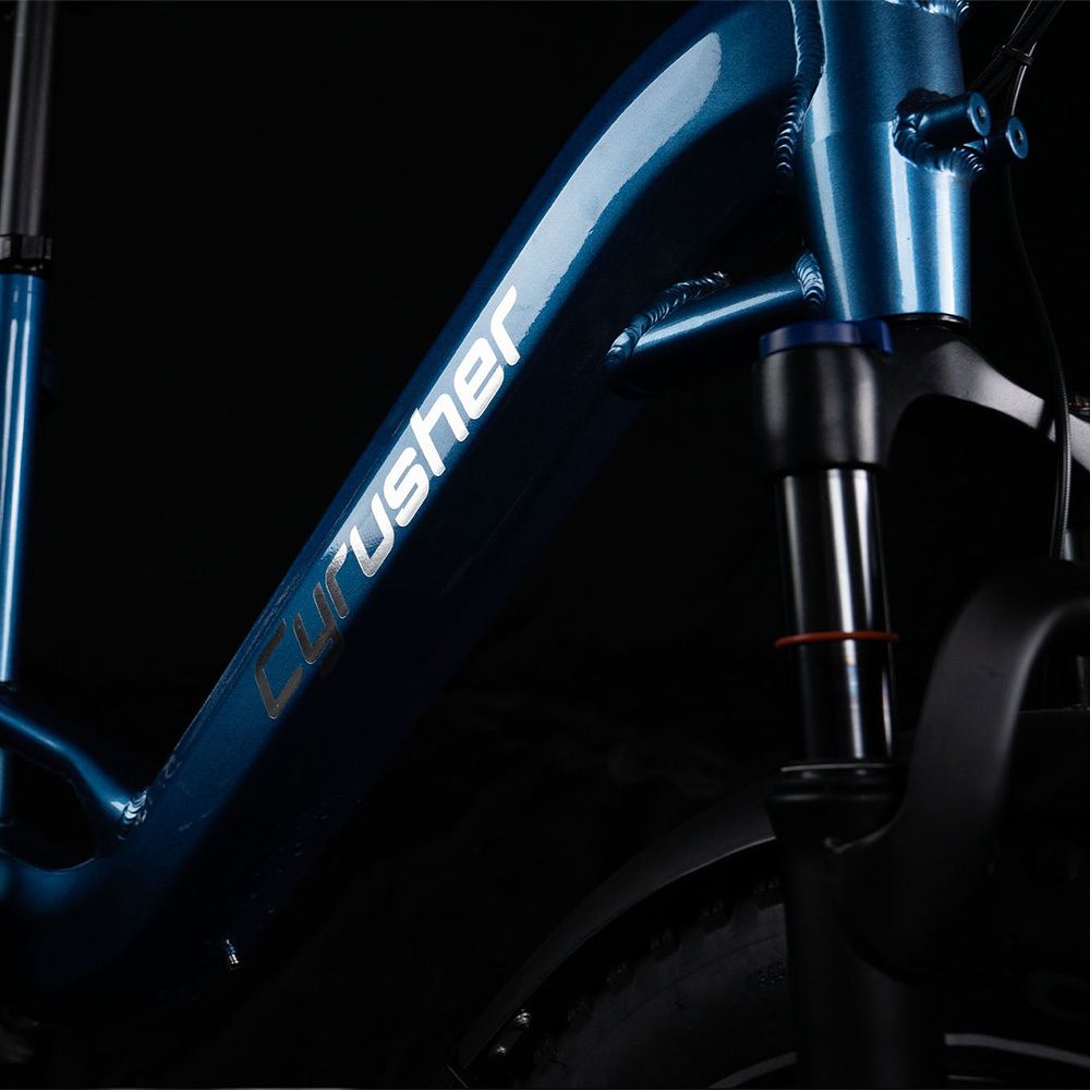 Gros plan sur le cadre d'un vélo électrique bleu. Logo CYRUSHER en blanc. Suspension avant.