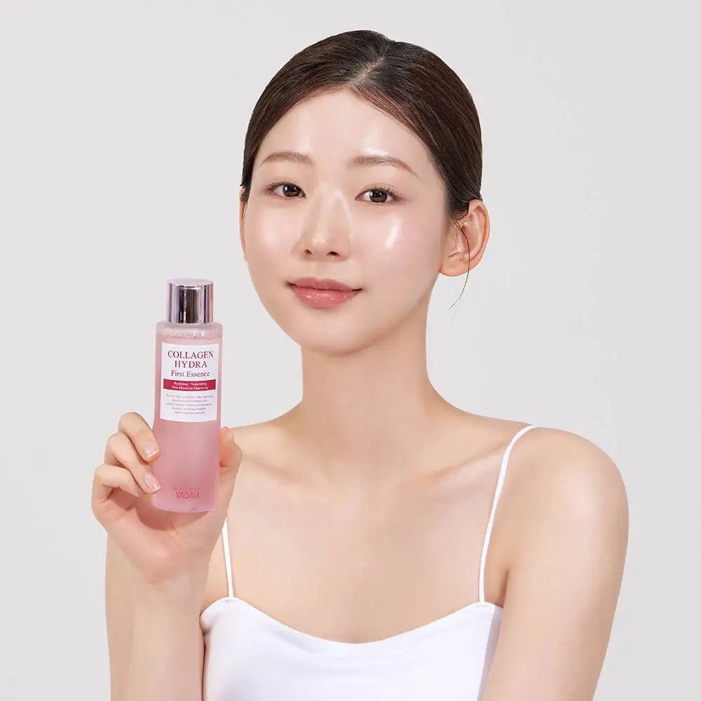Vrouw houdt een fles "Collagen Hydra Fine Essence" met roze vloeistof vast.