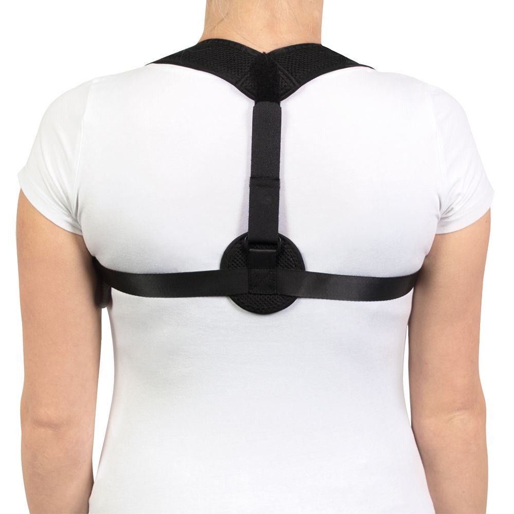Persoon draagt zwarte houding corrector. Achteraanzicht. De banden lopen over de schouders en rug. Een ronde sluiting bevindt zich op de rug.