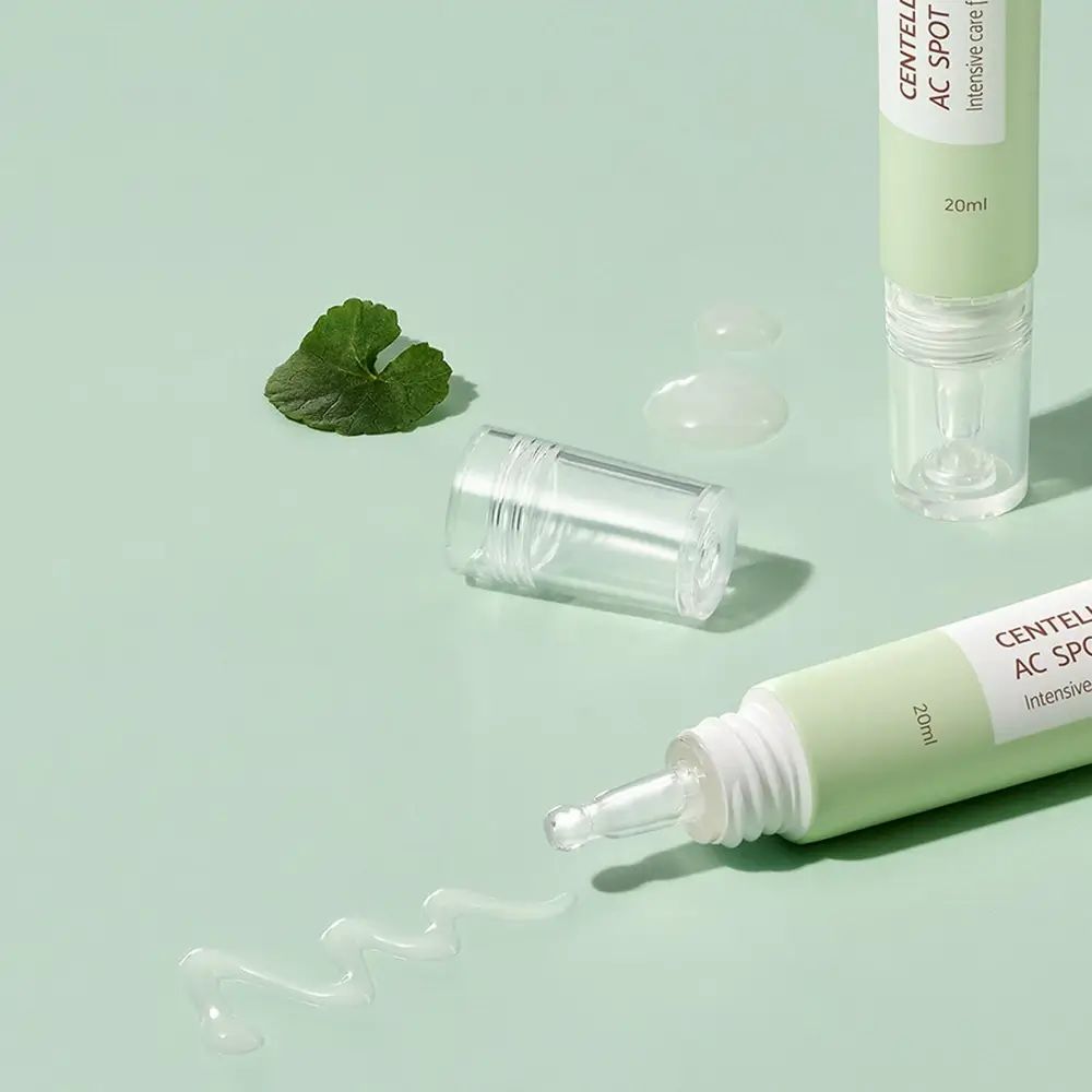 Deux tubes verts avec applicateurs. Inscription : Centella Calming AC Spot Cream. Crème et feuilles sorties.