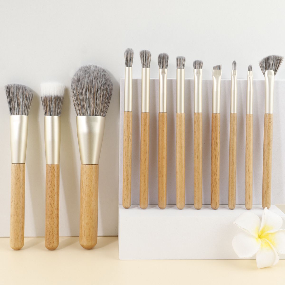 Ensemble de 10 pinceaux de maquillage avec manches en bois et viroles argentées.