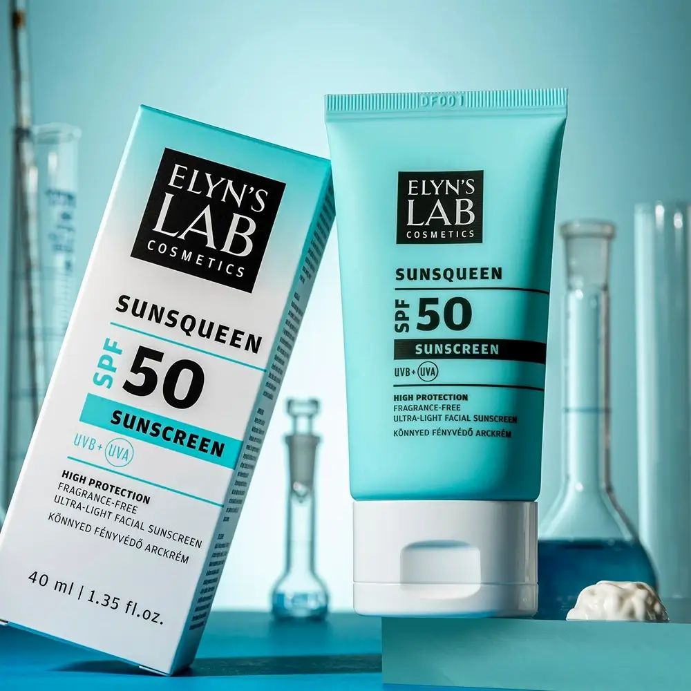 Turquoise tube en doos. Opdruk: ELYN'S LAB, SUNSQUEEN SPF50, zonnebrandcrème. 40 ml. Achtergrond: laboratoriumbenodigdheden.