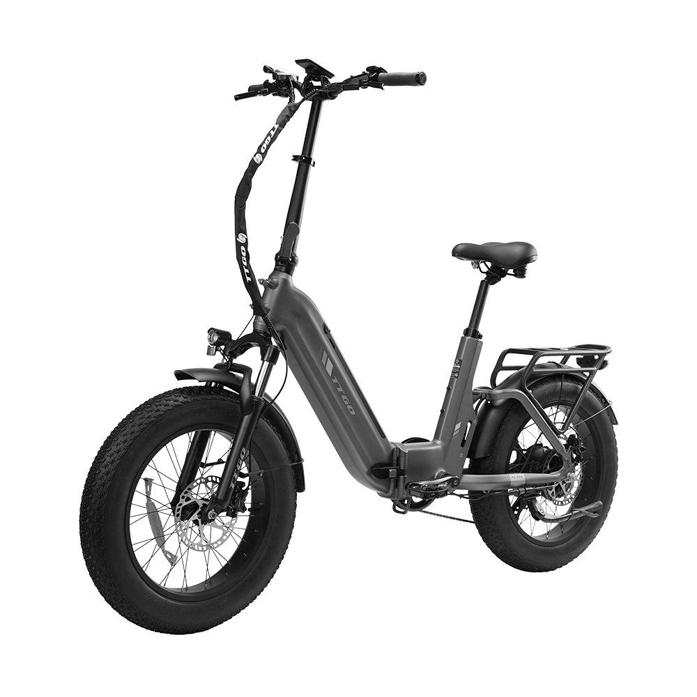 Vélo électrique pliable gris avec pneus noirs et accents orange. Il possède un porte-bagages et des freins à disque hydrauliques.