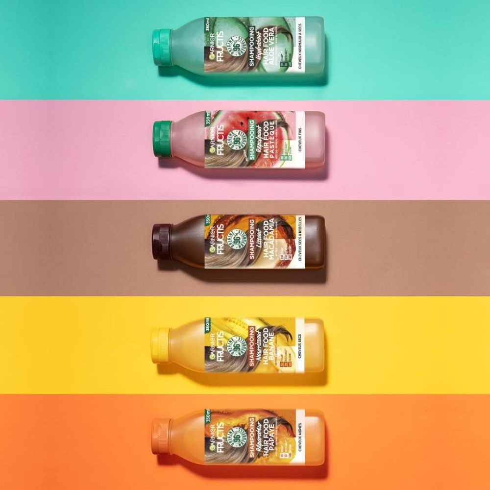 Vijf shampoo flessen, Garnier Fructis Hair Food, Aloe Vera. Verschillende kleuren, groene dop. Opschrift: Shampoo, Aloe Vera, 98% natuurlijke oorsprong.