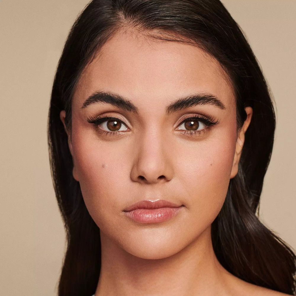 Portret van een vrouw met valse wimpers. De wimpers zijn zwart en benadrukken de ogen. De vrouw heeft donker haar.