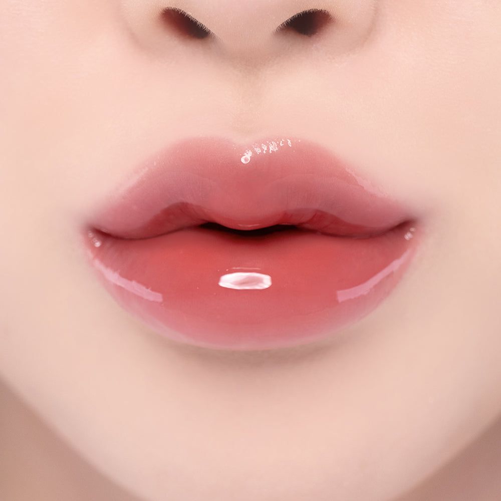 Close-up van volle, glanzende lippen met een roze lipgloss.