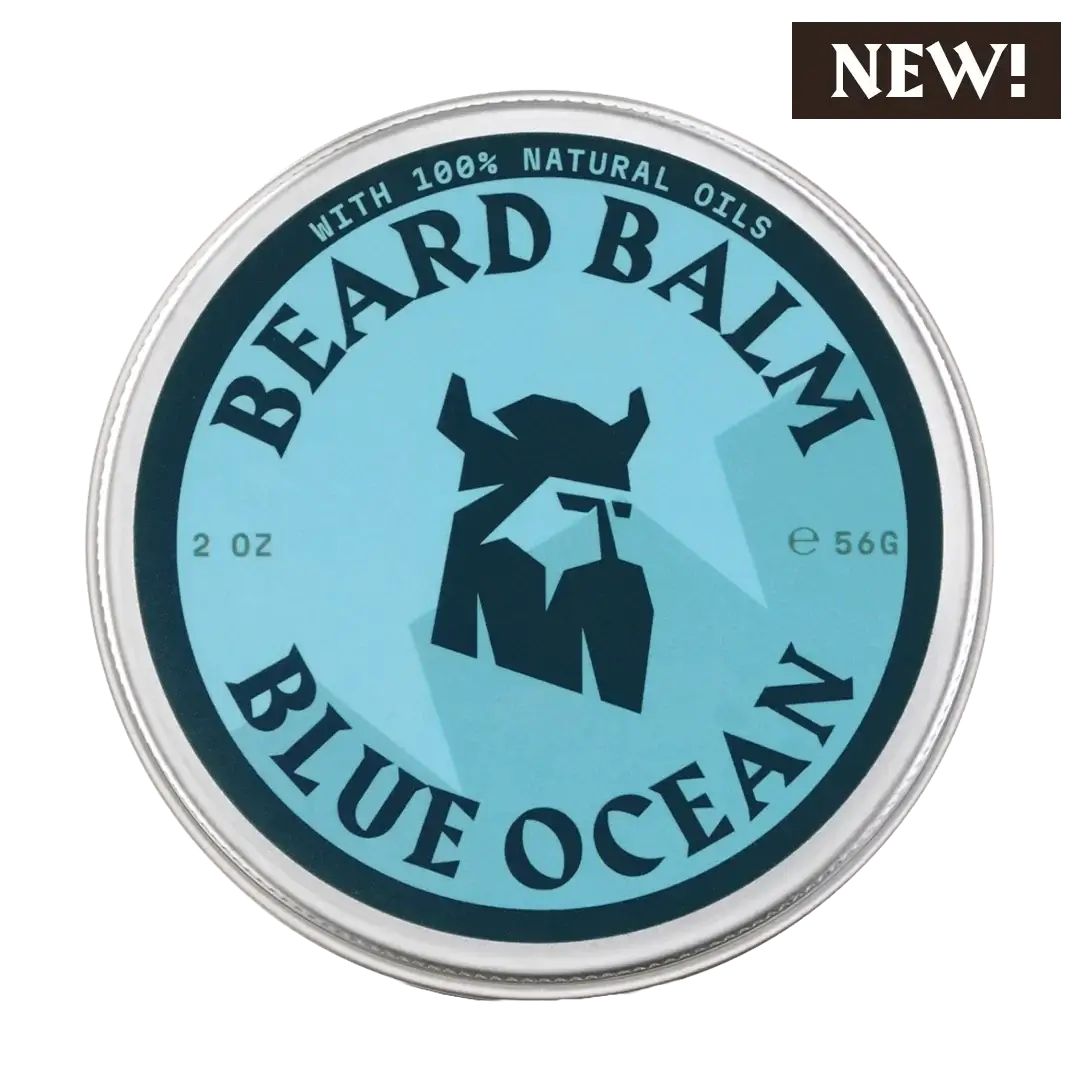Boîte ronde avec étiquette bleue. Inscription: BEARD BALM, BLUE OCEAN. Logo: tête de Viking. Texte: WITH 100% NATURAL OILS, 2 OZ, e 56G. Autocollant: NEW!